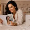 Woman reading a FAUSTINA instruction booklet beside the product presentation box